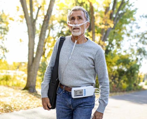 A man goes on a walk with his respiratory care device